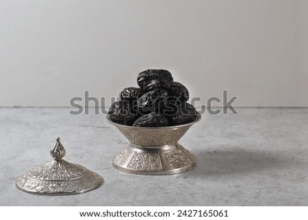 Kurma Ajwa, Ajwa Dates, served in traditional metal arabic bowl. Kurma Ajwa is one of the special fruit from Madina City. Typical Food During Ramadan. Selective Focus. Royalty-Free Stock Photo #2427165061