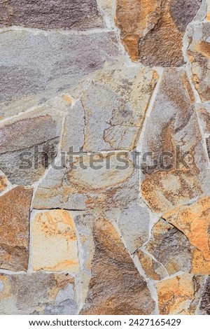 It is photo of a colorful big stones in wall. It is close up view of multicolored stone wal. This is a texture for designer. 