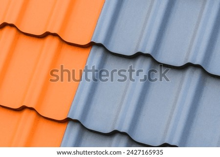 It is a photo of light brown and a grey roof tiles. It is close up view of colorful tiles of roof