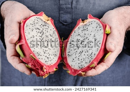 Pitaya fruit. Close-up of hands with dragon fruit. Healthy eating concept, tropical fruit.