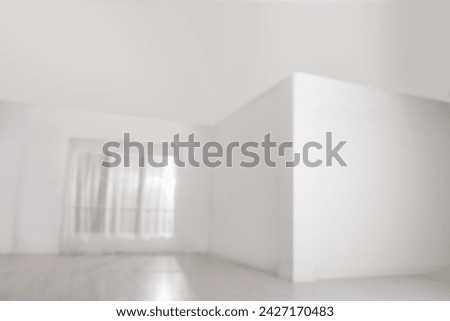 Empty room with white walls and large window, blurred view