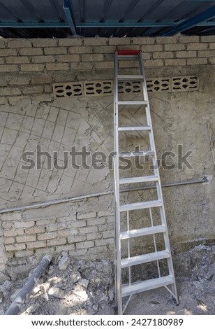 Picture of ladder  with ten steps  beside the wall.Now day, economic global so low, peoples with  low money make their own house to cut their cost.