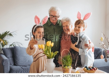 Grandparents taking selfie with grandchildren before traditional easter lunch. Recreating family traditions and customs. Happy easter. Royalty-Free Stock Photo #2427186135