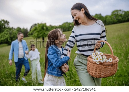 Family on interesting walk in forest, going through meadow. Mushroom, herbs medical plants or flowers picking, foraging. Concept of family ecological hobby in nature. Royalty-Free Stock Photo #2427186341