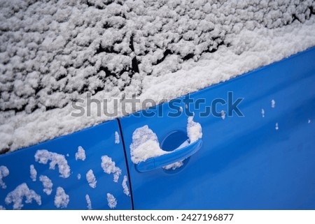 A blue car door in the snow.