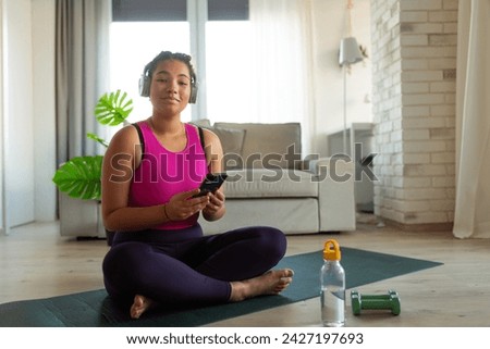 Woman resting after home workout, New Year's resolutions, healthy lifestyle, losing weight and selfcare. Concept of morning or evening exercise. Royalty-Free Stock Photo #2427197693