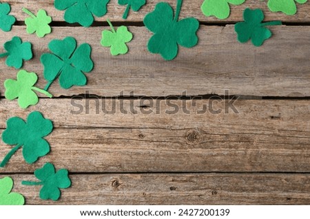 St. Patrick's day. Decorative clover leaves on wooden background, flat lay. Space for text