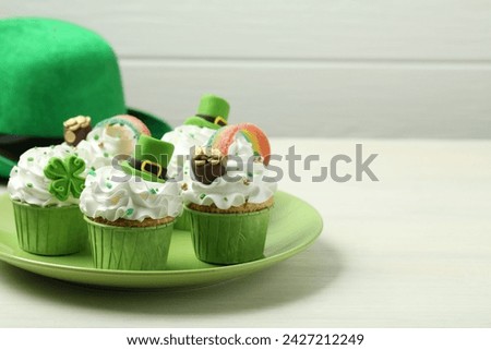 St. Patrick's day party. Tasty festively decorated cupcakes on white table, closeup. Space for text