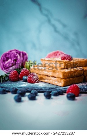 Mouthwathering picture of waffles , garnisched with some berries and sugar. Perfect for your food blog. 