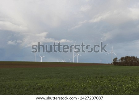cultivated field with windmills in the background