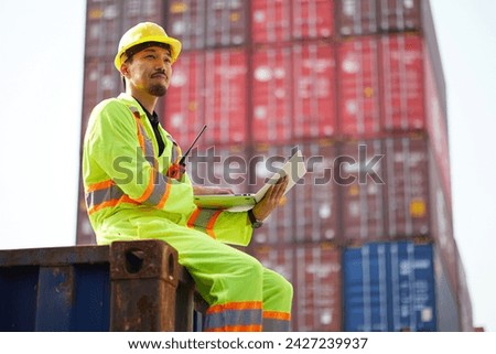 worker or engineer using laptop computer and checking work in containers warehouse storage