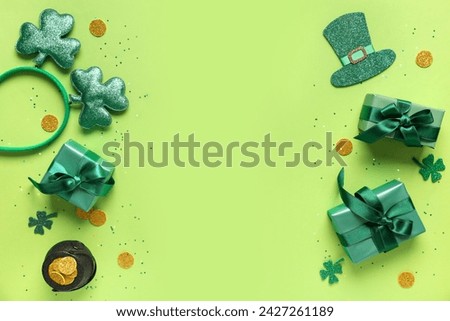 Gift boxes with headband, pot of golden coins and decor for St. Patrick's Day celebration on green background