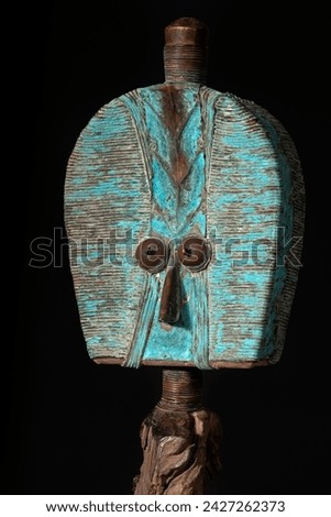 Close up of a wooden Kota reliquary figure from Gabon, isolated on a black background. Tribal African art, showcasing masterful craftsmanship and spiritual symbolism. Royalty-Free Stock Photo #2427262373