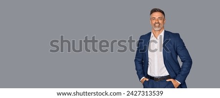 Smiling confident latin hispanic mature business man standing isolated on grey background. Older senior businessman, 40s 50s male professional ceo, coach, leader looking at camera. Banner, copy space.