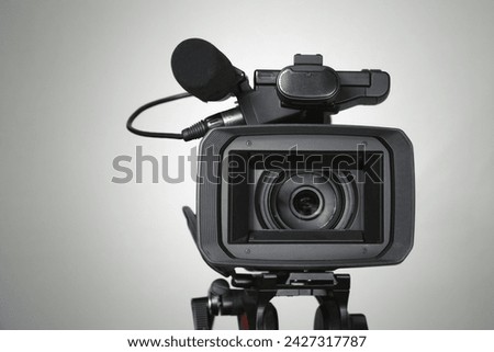 Video camera on a white background with a wide lens, video shooting with a professional camera