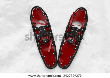red snowshoes on snow, close-up view, winter hiking concept, active lifestyle