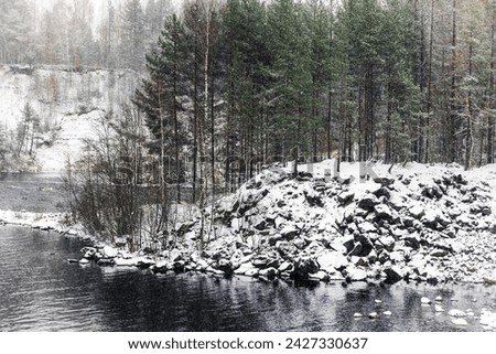 Snowy coasts of Suna River on a cold cloudy winter day, landscape photo of Girvas village, Kondopoga District, Republic of Karelia, Russia