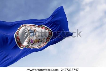Virginia state flag waving in the wind on a clear day. State seal in the middle of a dark blue background. 3d illustration render. Rippling fabric Royalty-Free Stock Photo #2427333747
