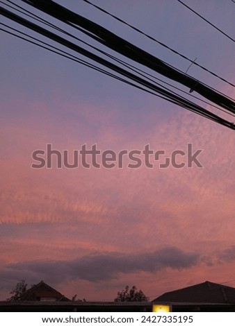 view of the sky in the afternoon along with dangling electricity cables 