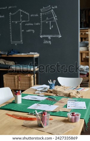 Vertical background image of atelier workshop interior with sewing patterns on blackboard, copy space Royalty-Free Stock Photo #2427335869