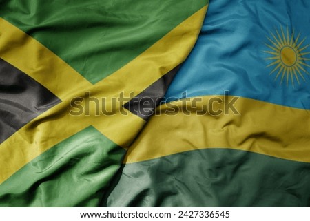 big waving national colorful flag of rwanda and national flag of jamaica . macro