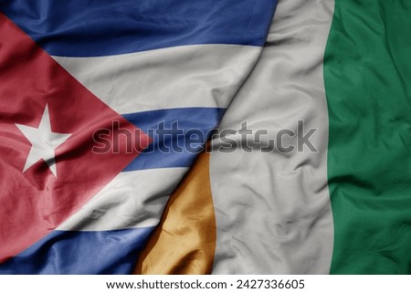 big waving national colorful flag of cote divoire and national flag of cuba . macro