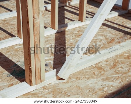 OSB sub flooring sheets cover, attach to the joists with wood screws Oriented Strand Board plywood, timber framing with posts beams studs of new house construction, interior wall framing, Texas. USA Royalty-Free Stock Photo #2427338049