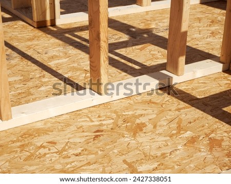 Oriented Strand Board OSB sub flooring and interior wall framing of new house construction, timber framing with posts beams studs, sheets cover joists with subfloor wood screws, Dallas, Texas. USA Royalty-Free Stock Photo #2427338051
