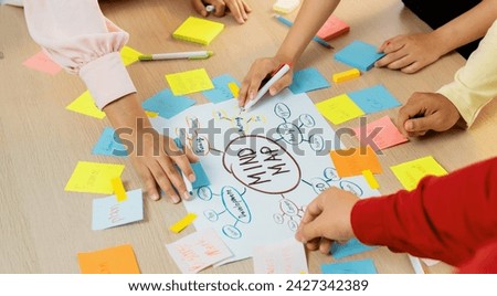 Creative business team brainstorming about marketing strategy and business plan by using mind mapping. Startup team work together to write down on paper. Focus on hand. Closeup. Variegated. Royalty-Free Stock Photo #2427342389