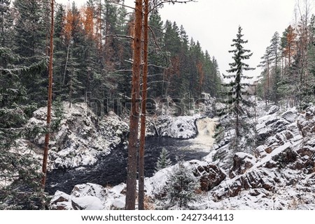 Kivach Falls on a snowy winter day. Landscape photo with cascade waterfall in the forest. Suna River, Kondopoga District, Republic of Karelia, Russia