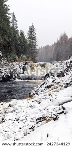 Vertical landscape photo with snowy cascade waterfall. Kivach Falls on a winter day. Suna River, Kondopoga District, Republic of Karelia, Russia