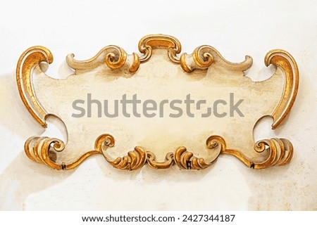 old sculptural plaque with gilded scrolls on the wall. mockup Royalty-Free Stock Photo #2427344187