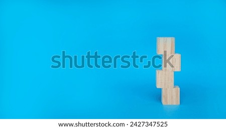 Cubic wooden block stacked on a blue background