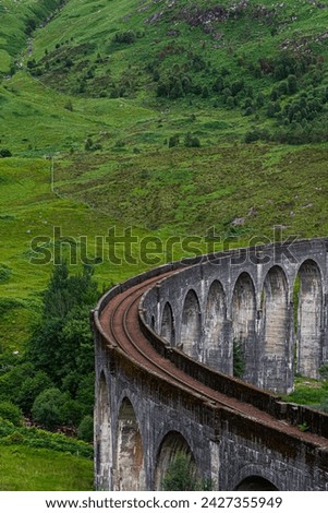 Traversing the Highland Rails: Stone Bridge Arching Over a Picturesque Scottish Valley Amidst Majestic Highlands Royalty-Free Stock Photo #2427355949