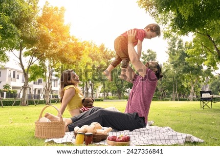 happy family spending time on summer day. Father lifted son into the air while picnicking in the park on a summer day Royalty-Free Stock Photo #2427356841
