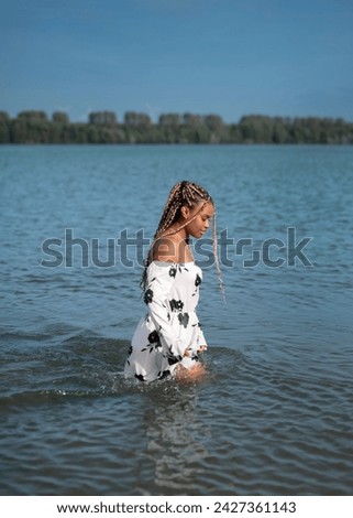 Beautiful woman in dress has fun inthe water