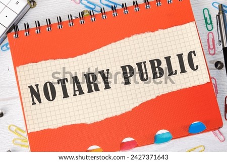 NOTARY PUBLIC is written on a piece of paper in a cage on the background of an orange notebook cover