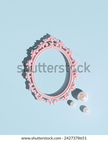 Baroque oval picture frame, pearl bead as decoration, creative copy space, pastel blue background.