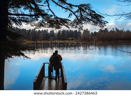 Two lovers are hugging each other against the view on the pier. Royalty-Free Stock Photo #2427386463