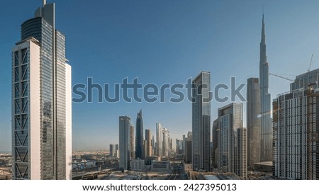 Aerial sunrise view of Dubai Downtown skyline with many towers night to day transition timelapse. Business area in smart urban city. Skyscrapers and high-rise buildings from above early morning, UAE. Royalty-Free Stock Photo #2427395013