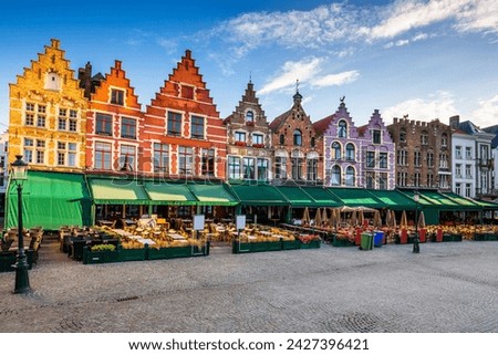 Bruges captivates with its picturesque canals, medieval buildings, and cobblestone streets. This stunning image showcases the iconic landmarks of Bruges, including the majestic Belfry towering  Royalty-Free Stock Photo #2427396421