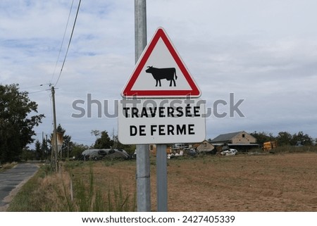 A French warning sign with the text "Traversée de Ferme," which translates to "Farm Crossing" in a rural environment.