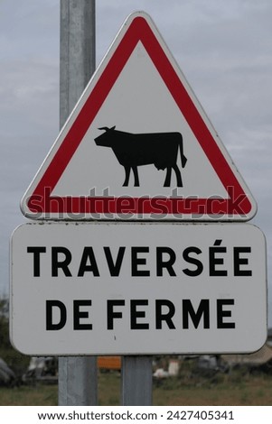 A French warning sign with the text "Traversée de Ferme," which translates to "Farm Crossing" in a rural environment.