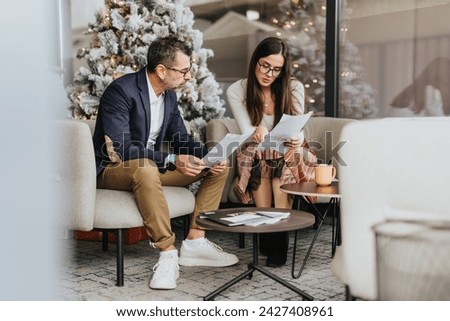 Creative business partners collaborating on growth strategies, analyzing statistics, and discussing project development. Cozy workplace with diverse colleagues working together. Royalty-Free Stock Photo #2427408961