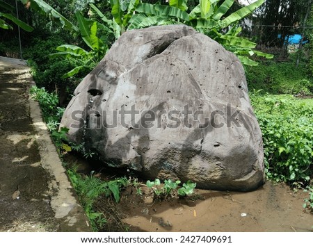 Photo of a large stone located in a village settlement