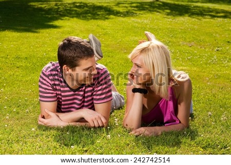Young couple lying in the park on a sunny day.