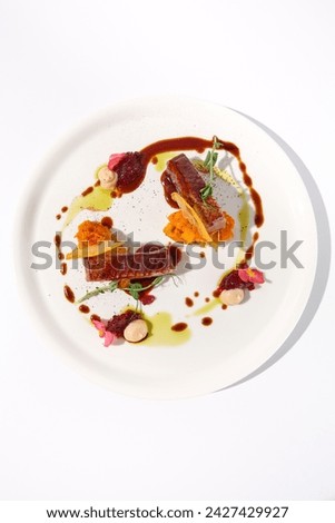 Duck fillet with onion marmalade and pumpkin puree, showcased on a pristine white plate, top view - perfect for culinary art presentations.