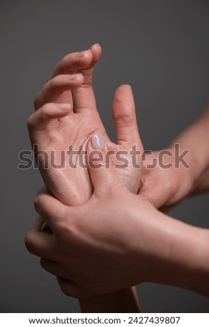 The masseuse massages the client's palms. Close-up of hands at a spa treatment. Vertical photo. 