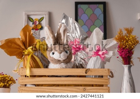 Rustic basket with colorful easter eggs and stuffed rabbit and easter decoration at table