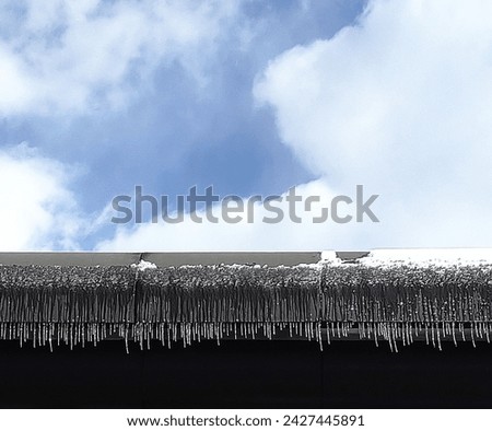 Icicles hang from a roof in a beautiful, sparkling row